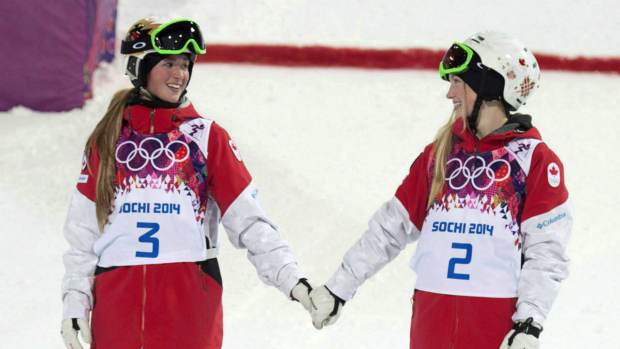 Canada's-Justine-Dufour-Lapointe-and-Chloe-Dufour-Lapointe-holds-hands-before-climbing-on-the-podium-after-winning-the-gold-and-silver-medals-in-the-moguls-at-the-Sochi-Winter-Olympics-Saturday-February-8,-2014-in-Sochi,-Russia.-(Adrian-Wyld/CP)