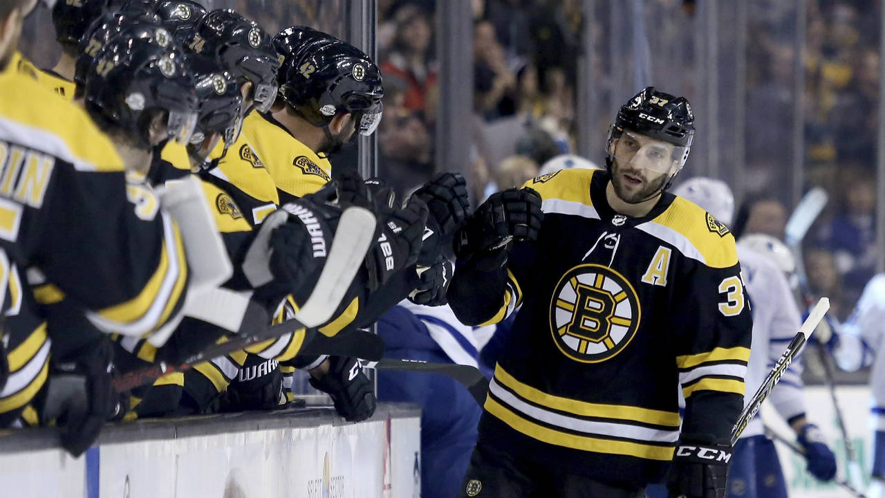 Boston-Bruins-centre-Patrice-Bergeron-(37)-is-congratulated-by-teammates-after-scoring-a-goal-during-the-first-period-of-an-NHL-hockey-game-against-the-Toronto-Maple-Leafs,-Saturday,-Feb.-3,-2018,-in-Boston.-(Mary-Schwalm/AP)