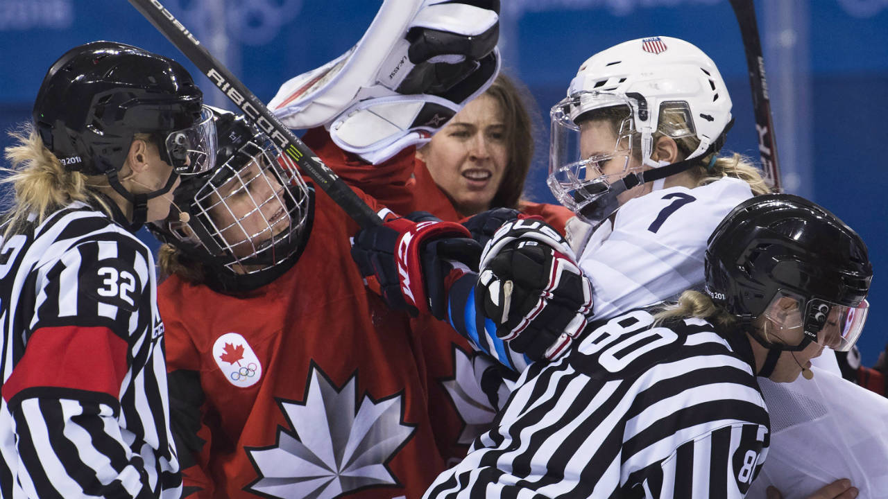 Canada-forward-Marie-Philip-Poulin-(29)-battles-with-United-States-forward-Monique-Lamoureux-Morando-(7)-as-Canada-goaltender-Genevieve-Lacasse,-centre,-had-her-helmet-taken-off-during-third-period-women's-olympic-hockey-action-at-the-2018-Olympic-Winter-Games-in-Gangneung,-South-Korea-on-Thursday,-February-15,-2018.-(Nathan-Denette/CP)