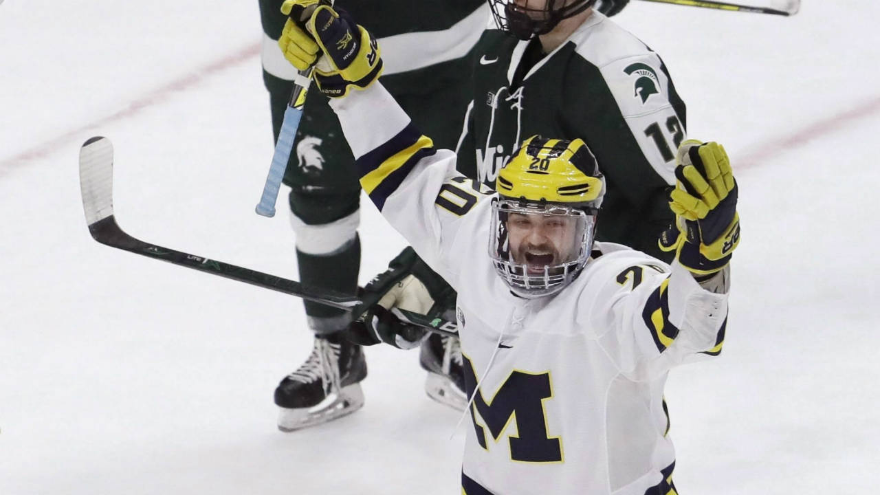 Michigan-forward-Cooper-Marody,-right,-reacts-after-his-hat-trick-goal-on-Michigan-State-goaltender-John-Lethemon-(31)-during-the-third-period-of-a-Great-Lakes-Invitational-college-hockey-game,-Tuesday,-Jan.-2,-2018,-in-Detroit.-Michigan-won-6-4.-(Carlos-Osorio/AP)