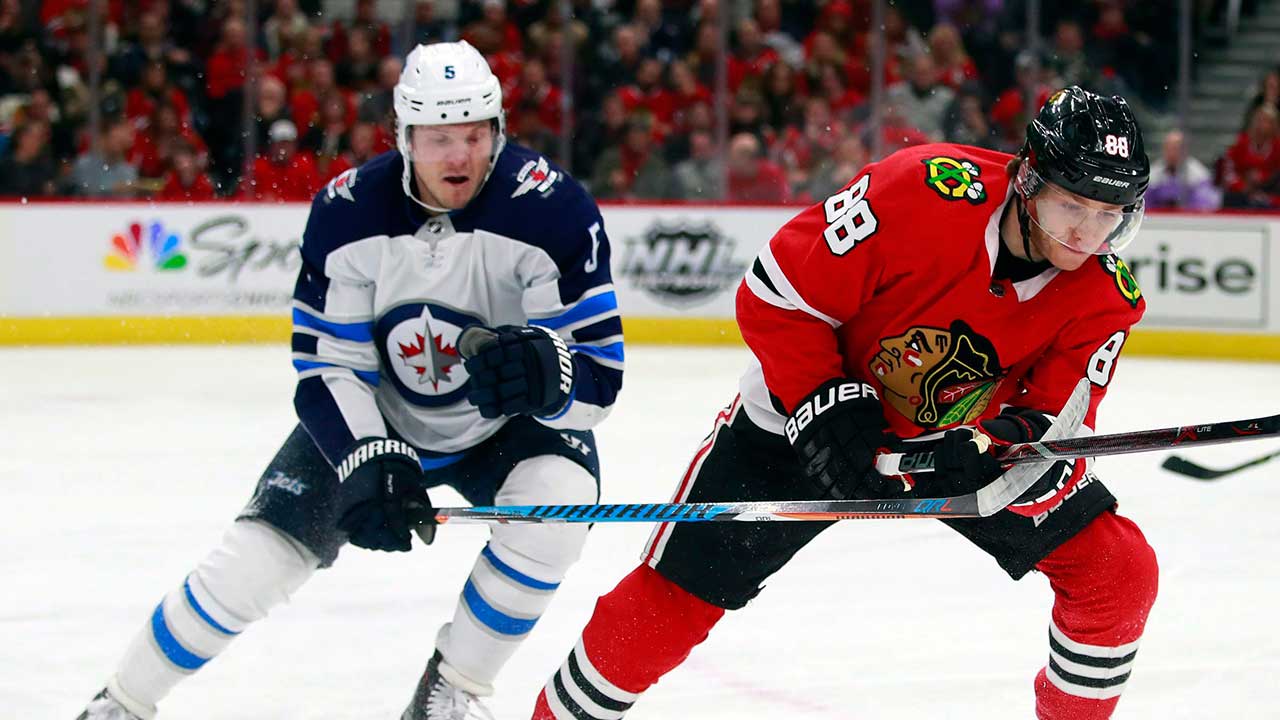Winnipeg Jets defenceman Dmitry Kulikov, left, battles with Chicago Blackhawks right wing Patrick Kane (88) for the puck, Friday, Jan. 12, 2018, in Chicago. (Jeff Haynes/AP)