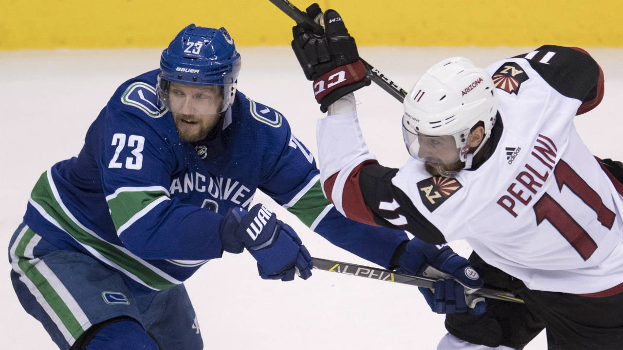 Vancouver-Canucks-defenceman-Alexander-Edler-(23)-fights-for-control-of-the-puck-with-Arizona-Coyotes-left-wing-Brendan-Perlini-(11)-during-second-period-NHL-action-in-Vancouver,-Wednesday,-March-7,-2018.-(Jonathan-Hayward/CP)
