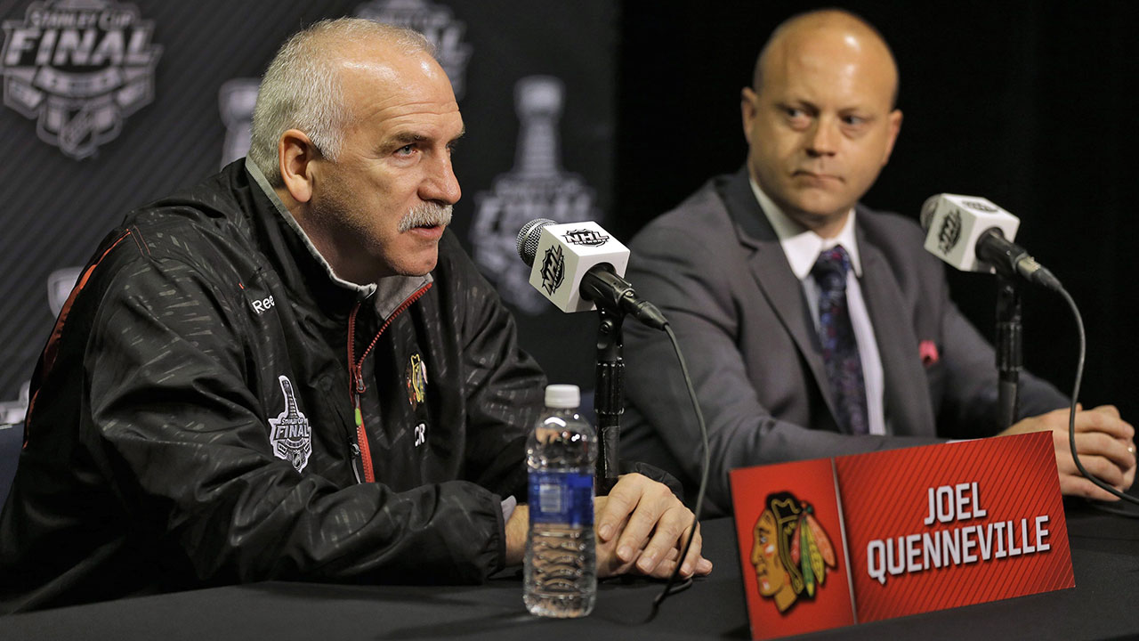 Chicago-Blackhawks-head-coach-Joel-Quenneville,-left,-answers-a-question-as-general-manger-Stan-Bowman-looks.