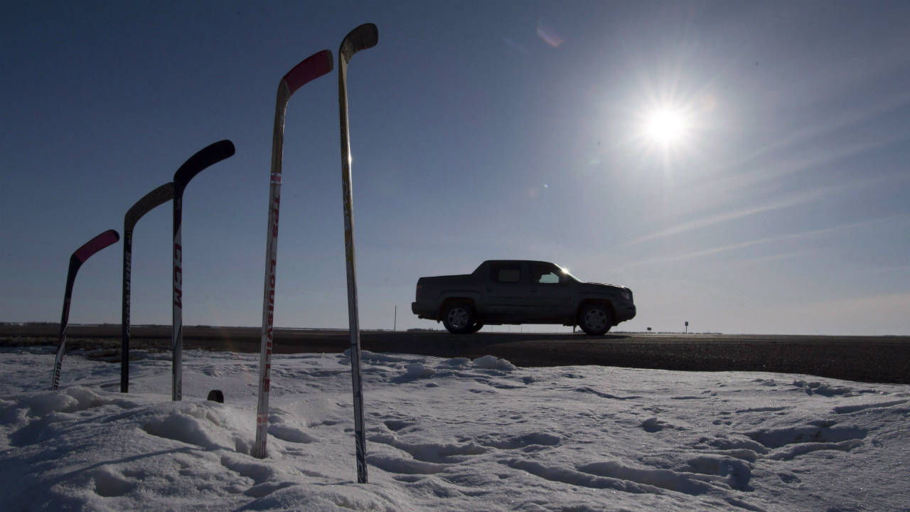 Hockey-sticks-to-remember-members-of-the-Humboldt-Broncos-are-silhouetted-against-the-morning-sun-along-a-stretch-of-highway-6-in-Saskatchewan,-Friday,-April,-13,-2018.-Today-there-is-a-public-memorial-for-18-year-old-Parker-Tobin,-20-year-old-Jaxon-Joseph,-18-year-old-Logan-Hunter-and-21-year-old-Stephen-Wack,-players-with-the-SJHL-Humboldt-Broncos-who-were-among-those-killed-when-the-team-bus-and-a-semi-truck-collided-at-an-intersection-in-rural-Saskatchewan.-(Jonathan-Hayward/CP)