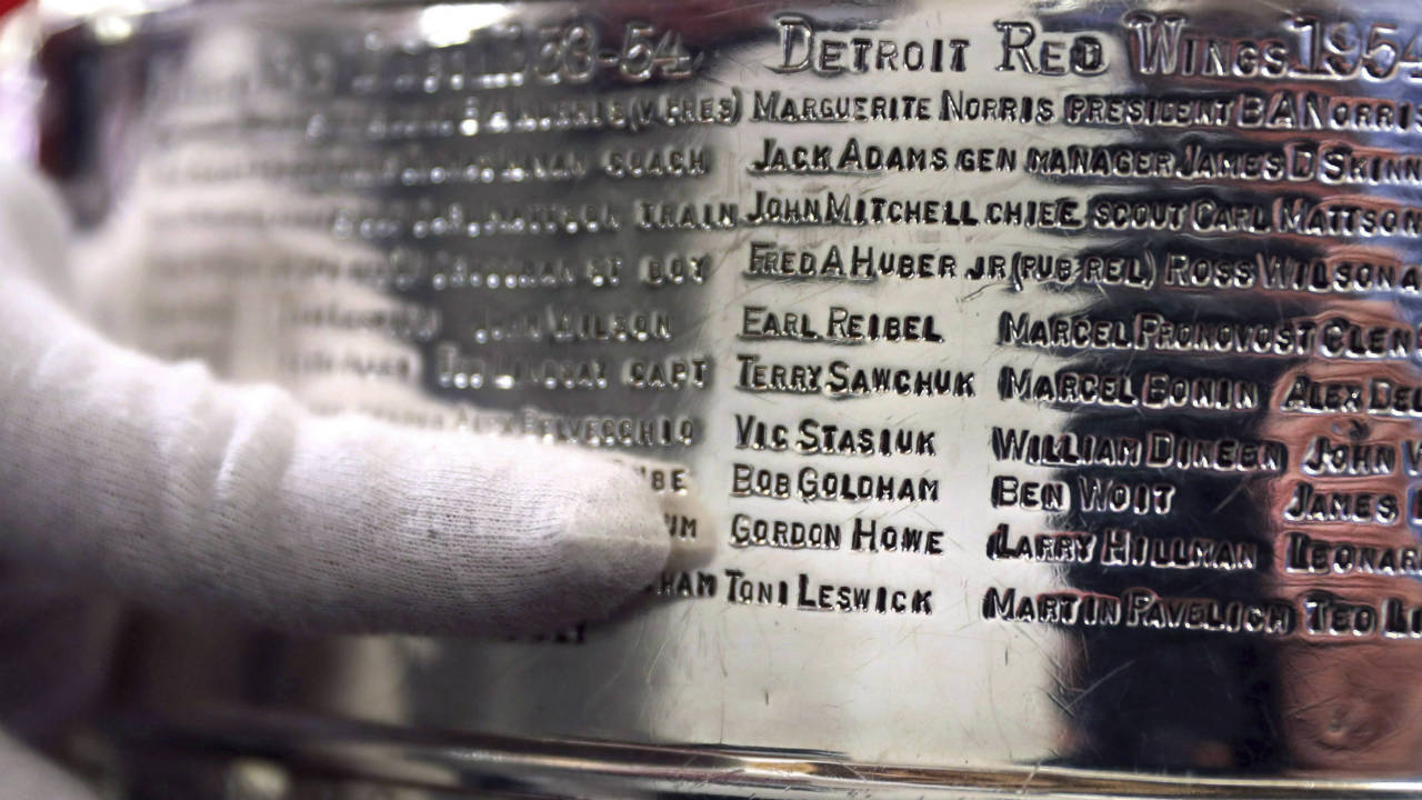 National-Hockey-League's-Mike-Bolt,-who-is-a-keeper-of-the-Stanley-Cup-when-it-travels,-points-out-Gordon-"Gordie"-Howe's-name-on-the-team-engraving-of-the-1954-1955-Detroit-Red-Wings-in-Boston,-Monday,-April-2,-2018.-The-names-of-Hockey-Hall-of-Famers-like-Bobby-Hull,-Maurice-"Rocket"-Richard-and-Howe-will-be-removed-from-the-Stanley-Cup-to-make-room-for-the-next-generation-of-champions.-When-a-new-layer-is-added-to-the-126-year-old-trophy,-the-championship-teams-from-1954-65-will-need-to-be-removed-so-the-trophy-doesn't-grow-too-big-to-travel.-(Charles-Krupa/AP)