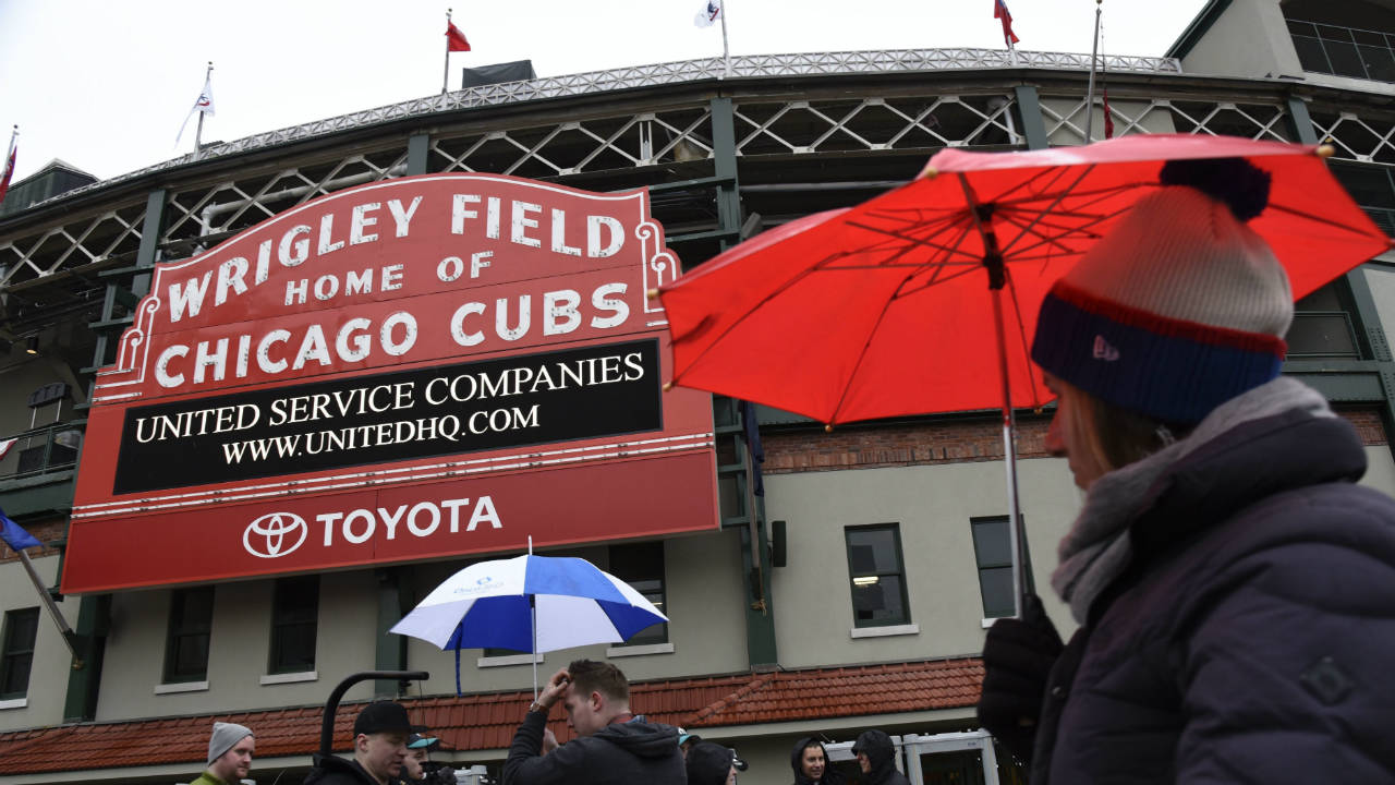 Fans-do-their-best-to-stay-warm-and-dry-outside-Wrigley-Field.-(Matt-Marton/AP)