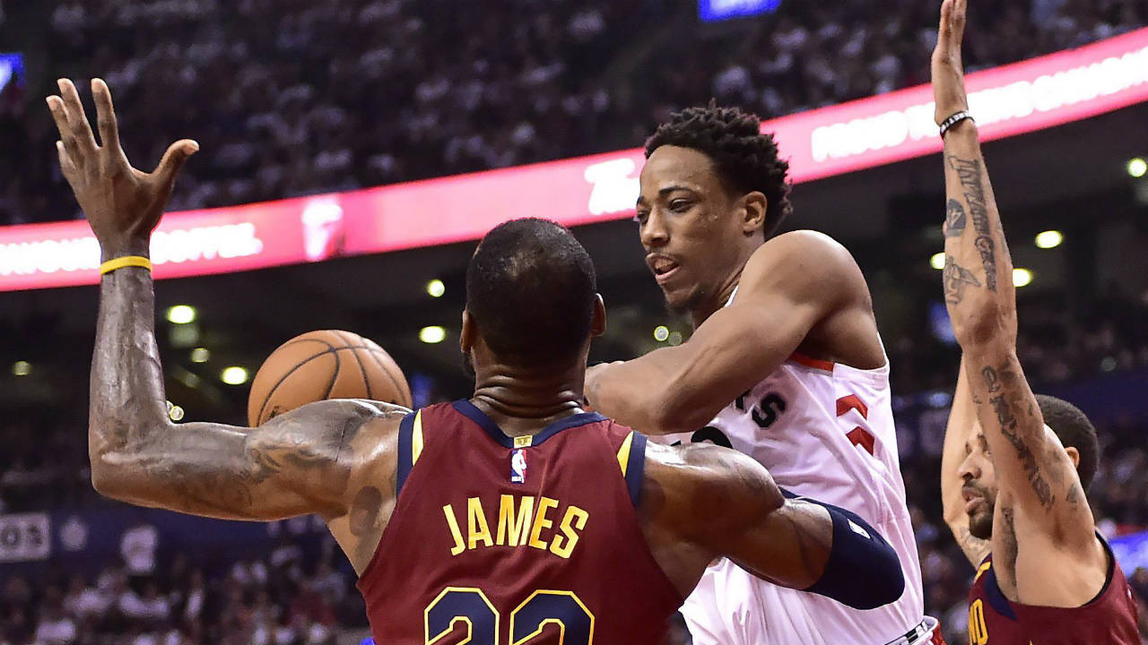 Toronto-Raptors-guard-DeMar-DeRozan-(10)-passes-off-under-pressure-from-Cleveland-Cavaliers-forward-LeBron-James-(23)-during-first-half-NBA-playoff-basketball-action-in-Toronto-on-Thursday,-May-3,-2018.-(Frank-Gunn/CP)