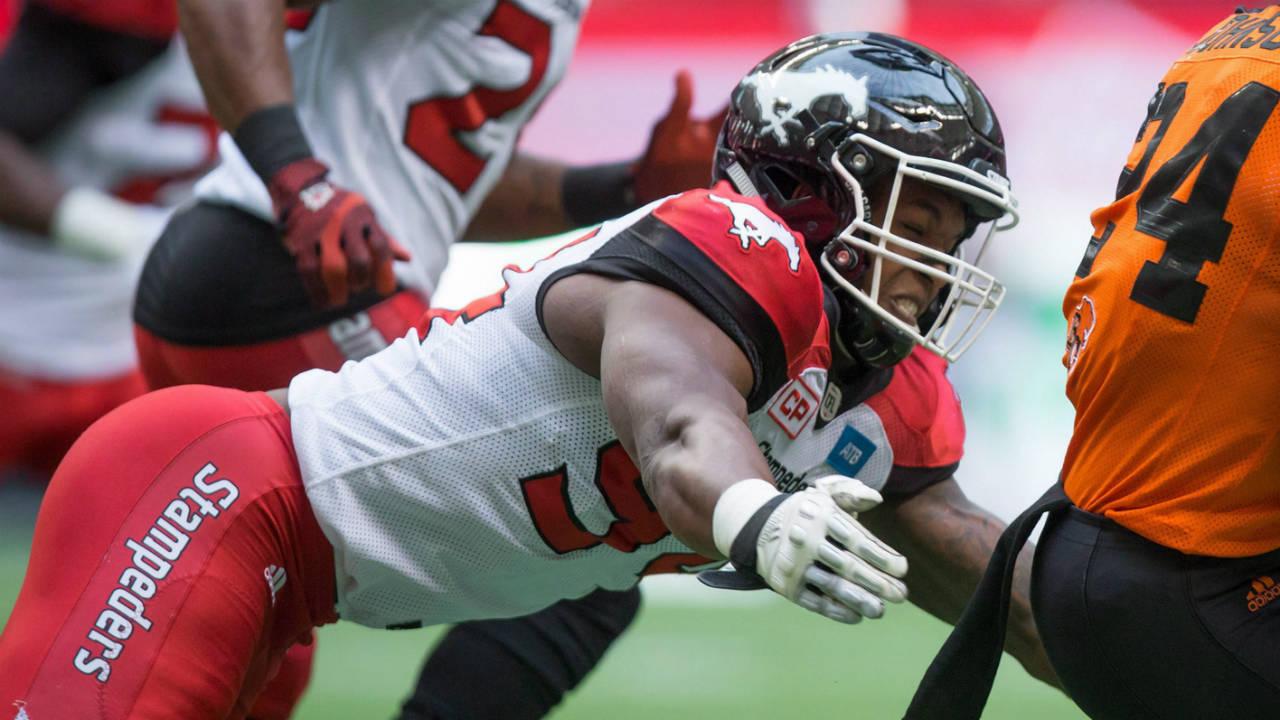 B.C.-Lions'-Jeremiah-Johnson,-right,-gets-away-from-Calgary-Stampeders'-Frank-Beltre-while-carrying-the-ball-during-the-first-half-of-a-pre-season-CFL-football-game-in-Vancouver,-B.C.,-on-Friday-June-17,-2016.-(Darryl-Dyck/CP)