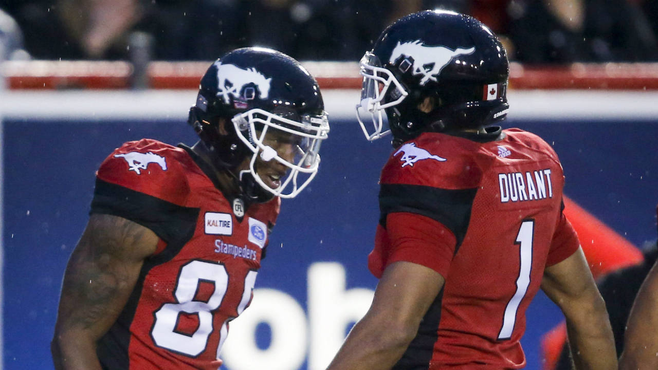 Calgary-Stampeders'-Kamar-Jorden,-left,-celebrates-his-touchdown-with-teammate-Lemar-Durant,-during-second-half-CFL-football-action-against-the-Ottawa-Redblacks-in-Calgary,-Thursday,-June-28,-2018.
