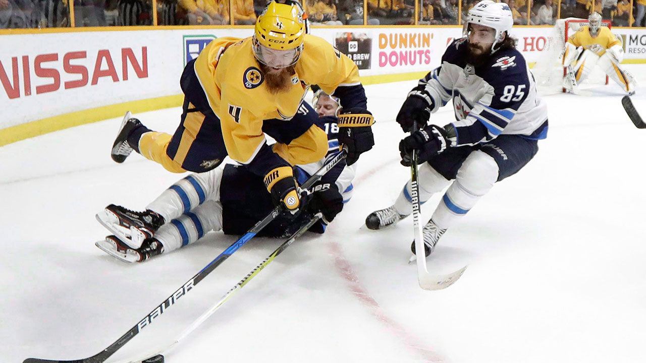Nashville Predators defenceman Ryan Ellis (4) jumps over Winnipeg Jets' Bryan Little (18) as Mathieu Perreault (85) closes in during Game 7 of their 2018 playoff series. (Mark Humphrey/AP)