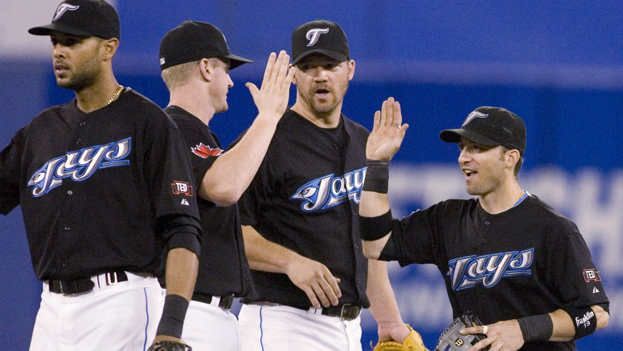 Toronto-Blue-Jays'-Scott-Rolen-(centre-right)-looks-on-as-Lyle-Overbay-(centre-left)-and-Marco-Scutaro-(right)-high-five,-while-Alex-Rios-(left)-walks-off-the-field-after-their-side-beat-the-Tampa-Bay-Rays-5-1-in-AL-action-in-Toronto-on-Sunday-July-26-2009.-THE-CANADIAN-PRESS/Chris-Young