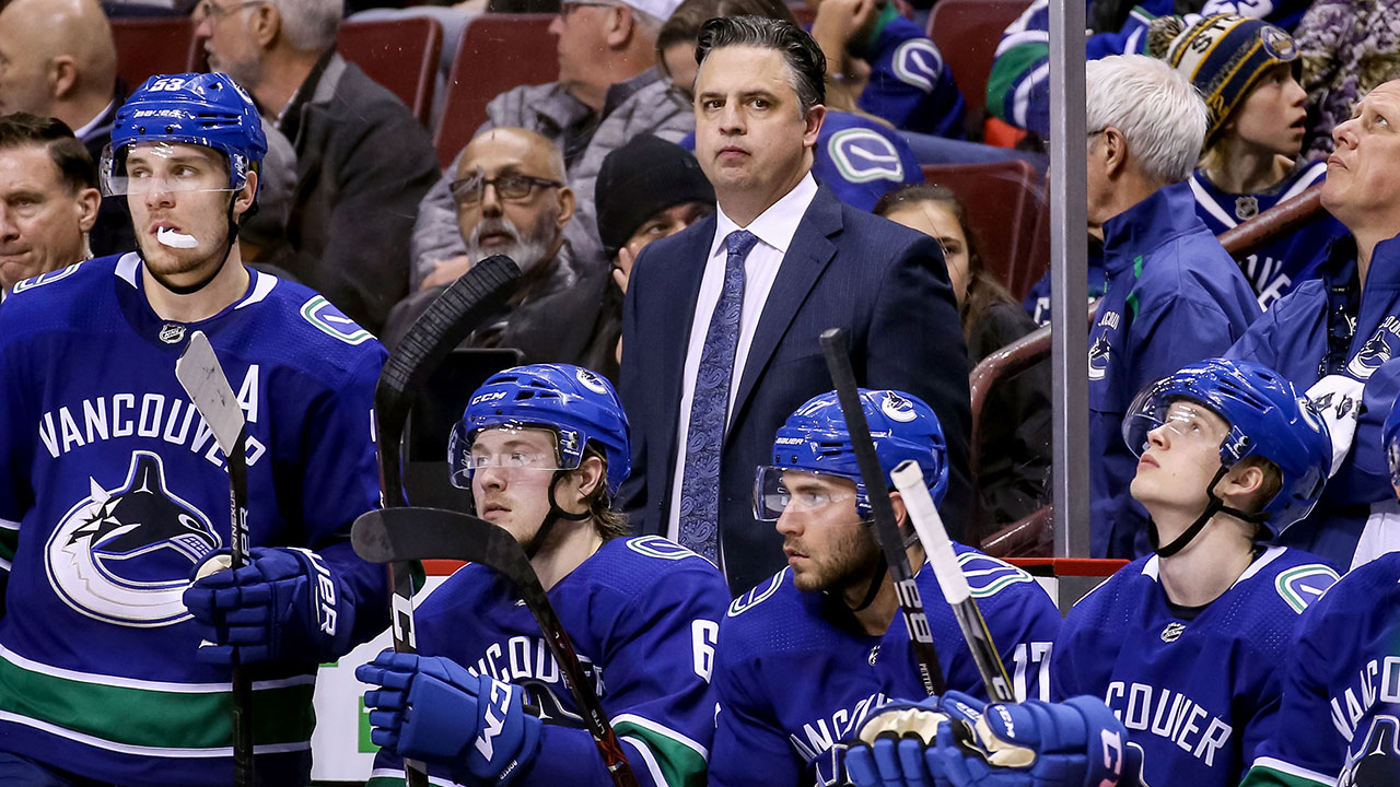 NHL-Canucks-Green-stands-behind-bench-during-game