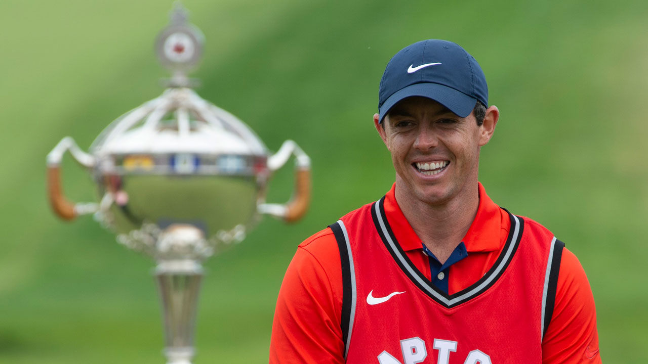 Rory-McIlroy-laughs-as-he-puts-on-a-Toronto-Raptors-jersey-during-the-trophy-presentation-at-the-Canadian-Open-golf-championship