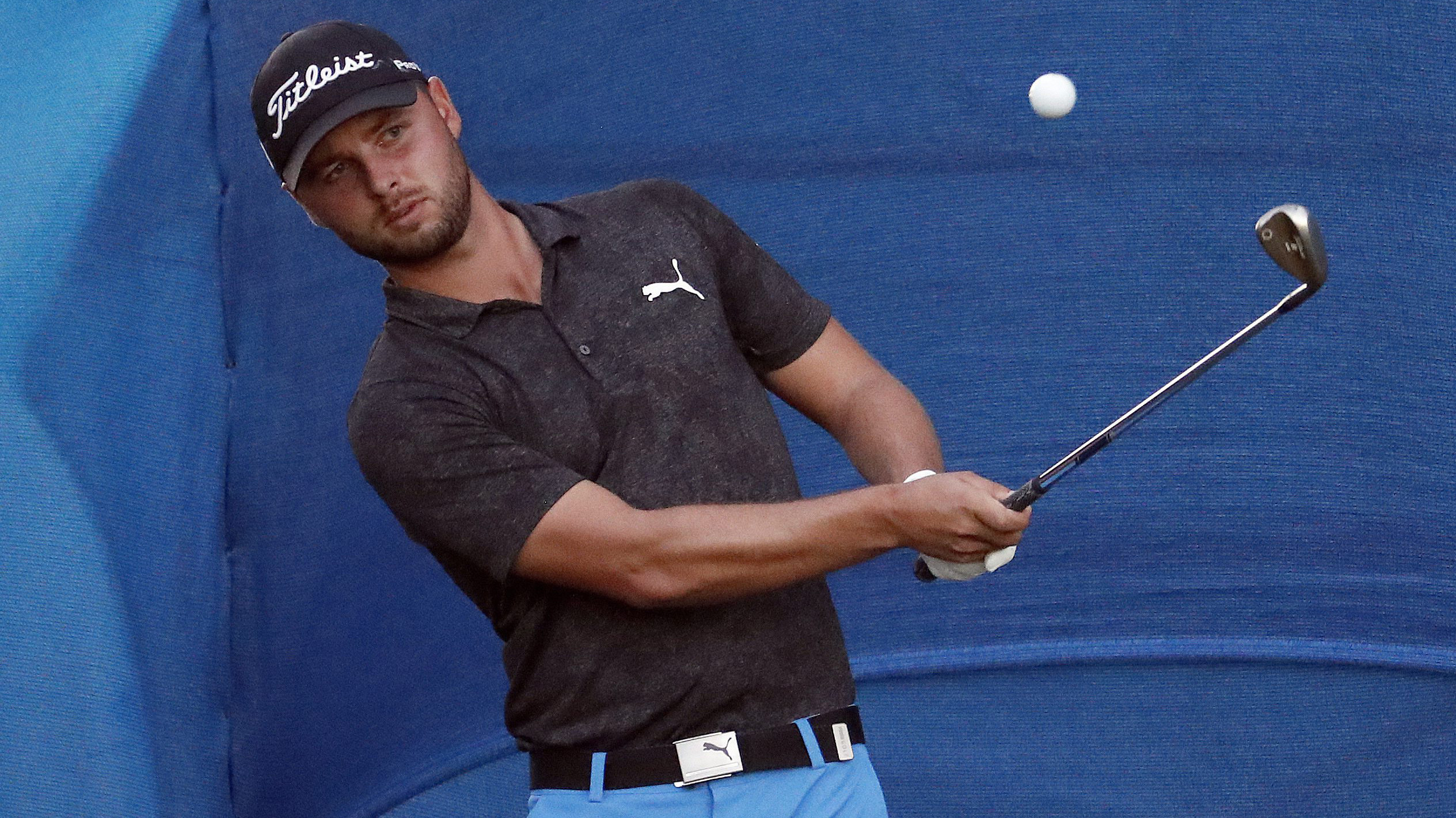 Adam Svensson chips onto the 18th green. (Matt York/AP)