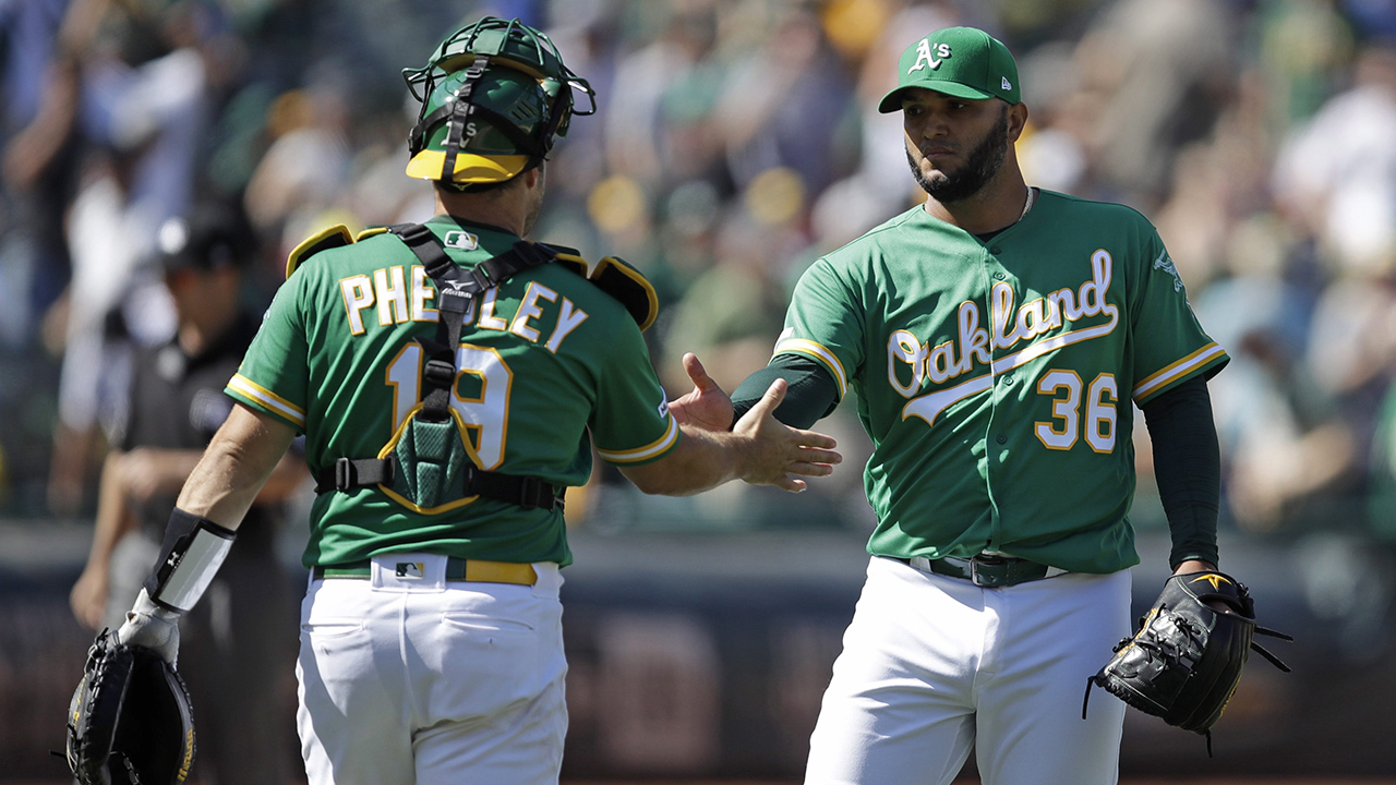 Oakland Athletics pitcher Yusmeiro Petit, right, celebrates the team's 8-4 win over the Houston Astros with catcher Josh Phegley at the end of a baseball game Saturday, Aug. 17, 2019, in Oakland, Calif. (Ben Margot/AP)