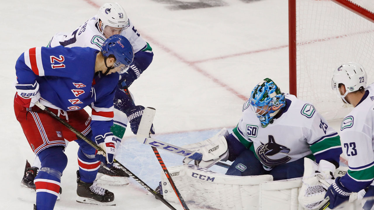 Vancouver Canucks defenceman Tyler Myers (57) defends against a shot by New York Rangers centre Brett Howden (21). (Kathy Willens/AP)