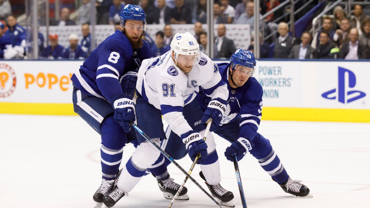 Tampa Bay Lightning centre Steven Stamkos (91) battles for the puck between Toronto Maple Leafs defenceman Jake Muzzin (8) and defenceman Justin Holl (3) during the third period of their NHL hockey game in Toronto, Thursday, Oct. 10, 2019. (Cole Burston/CP)