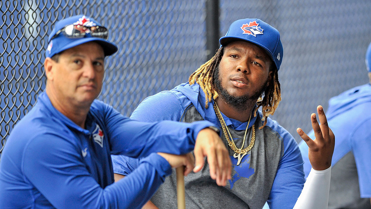 Toronto-Blue-Jays-manager-Charlie-Montoyo,-left,-and-infielder-Vladimir-Guerrero-Jr.-sit-outside-the-batting-cages