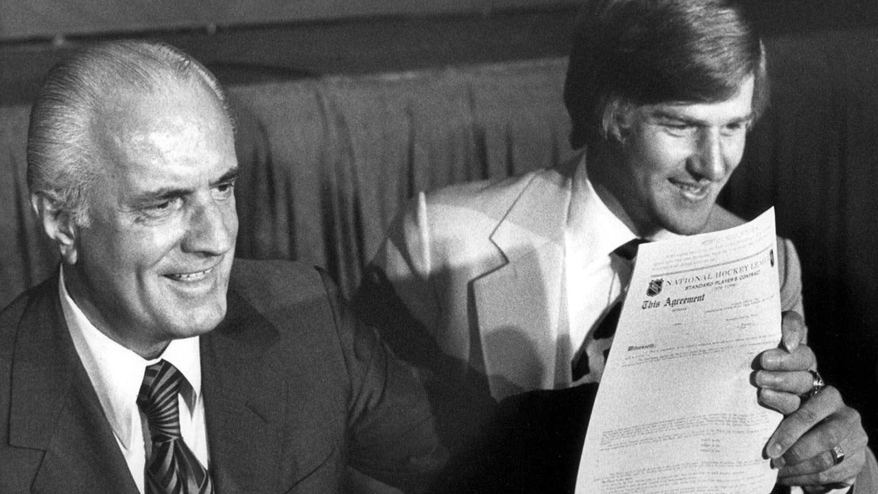 Bobby Orr holds his contract with the Chicago Blackhawks at signing ceremony in 1976
