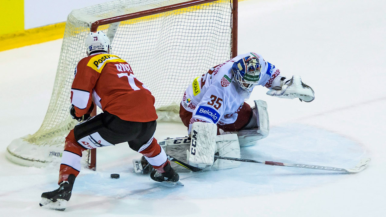 switzerlands-damien-riat-scores-on-belarus-goalie-ivan-kulbakov