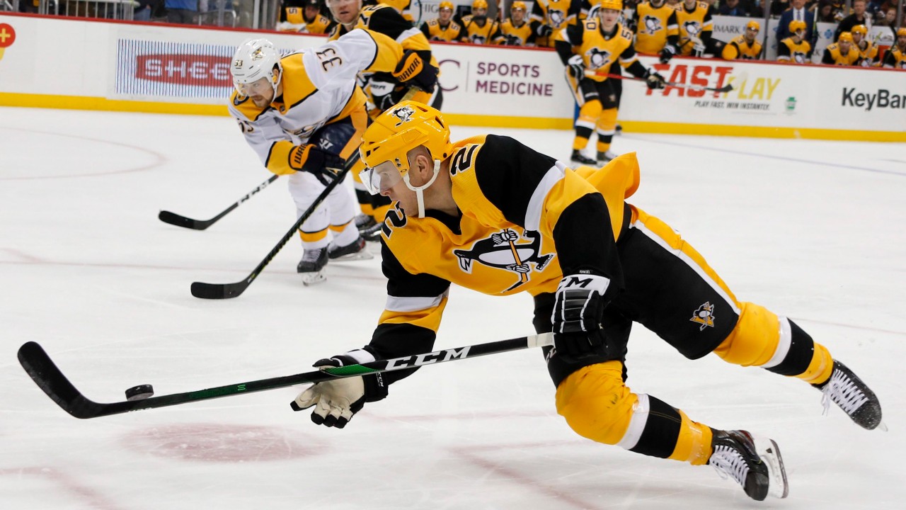 Pittsburgh Penguins' Chad Ruhwedel (2) dives to control the puck in front of Nashville Predators' Viktor Arvidsson (33) during the second period of an NHL hockey game. (Keith Srakocic/AP)