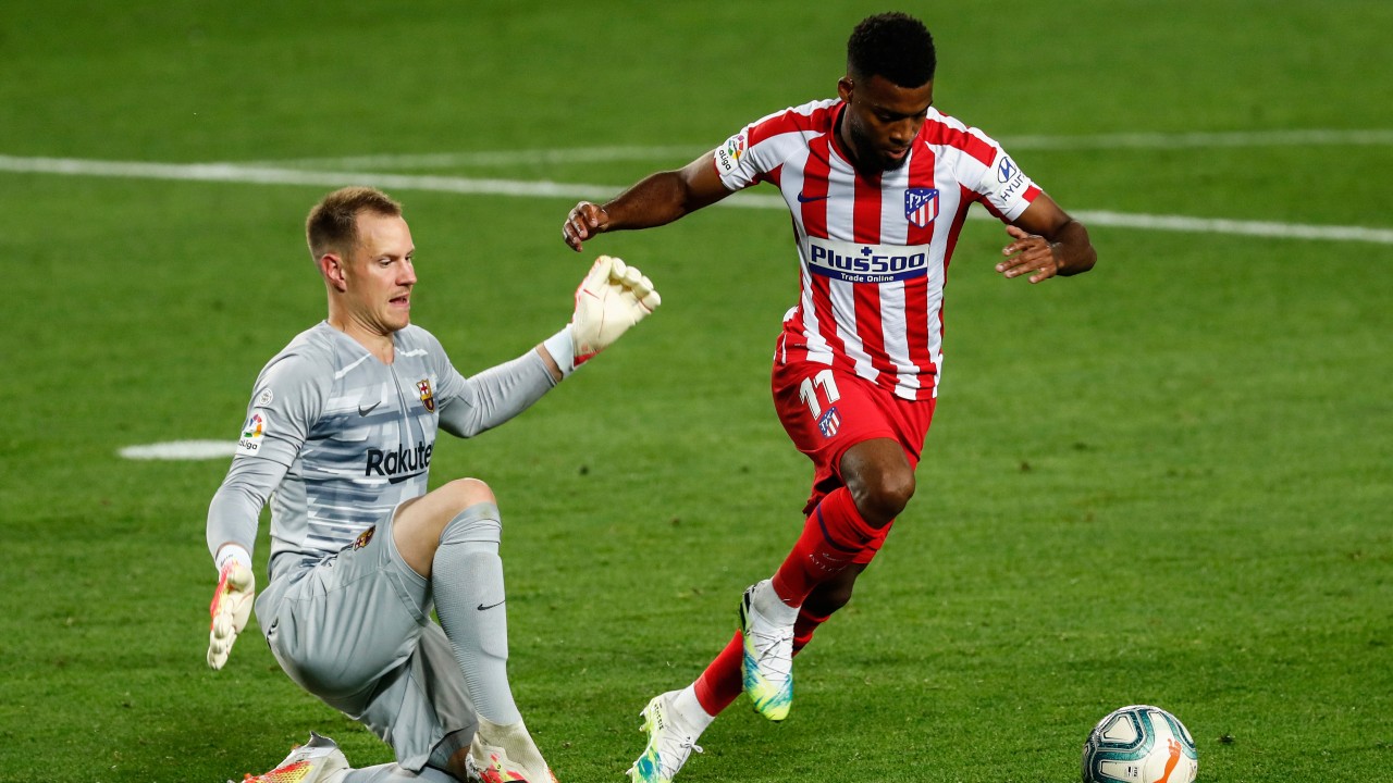 Atletico Madrid's Thomas Lemar views for the ball next to Barcelona's goalkeeper Marc-Andre ter Stegen during the Spanish La Liga soccer match between FC Barcelona and Atletico Madrid. (Joan Monfort/AP)