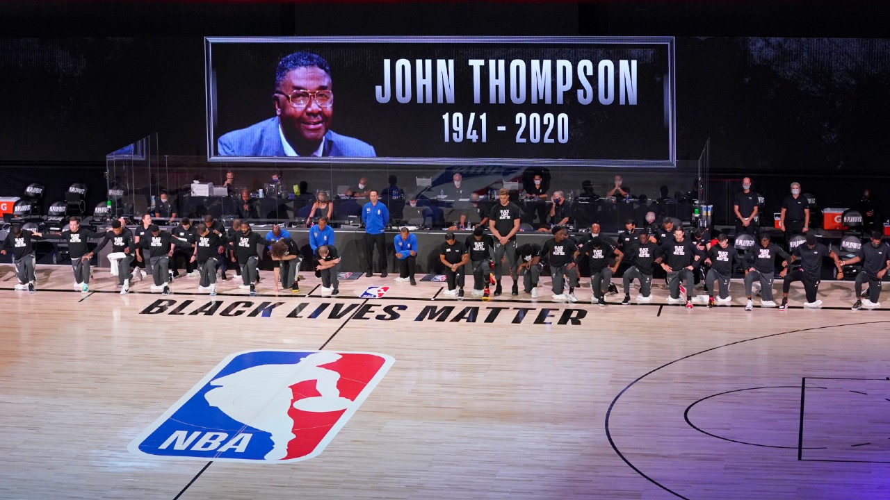 Members of the Miami Heat and the Milwaukee Bucks observe a moment of silence honoring the late John Thompson during the first half of an NBA basketball conference semifinal playoff game, Monday, Aug. 31, 2020, in Lake Buena Vista, Fla. (Mark J. Terrill/AP)