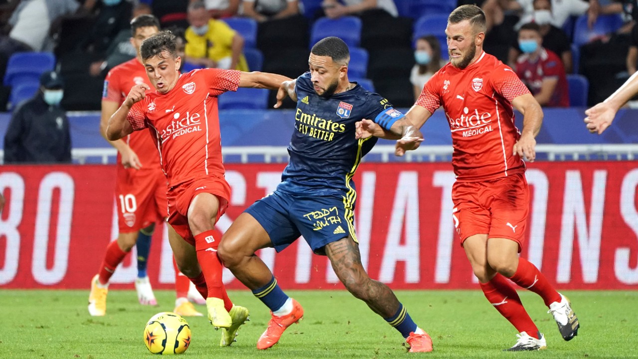 Lyon's Memphis Depay, center, challenges for the ball with Nimes' players during the French League One soccer match between Lyon and Nimes in Decines, near Lyon, central France, Friday, Sept. 18, 2020. (Laurent Cipriani/AP)