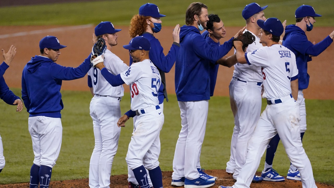 Los Angeles Dodgers right fielder Mookie Betts (50), shortstop Corey Seager (5) and teammates celebrate after the Dodgers clinched the NL West title with a 7-2 win over the Oakland Athletics in a baseball game Tuesday, Sept. 22, 2020, in Los Angeles. (Ashley Landis / AP)