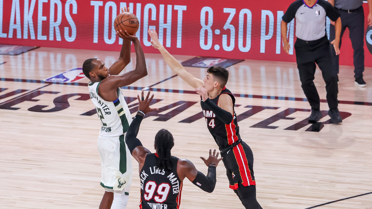 Bucks forward Khris Middleton (L) makes a three-point shot against the Heat. (Erik S. Lesser/EPA)