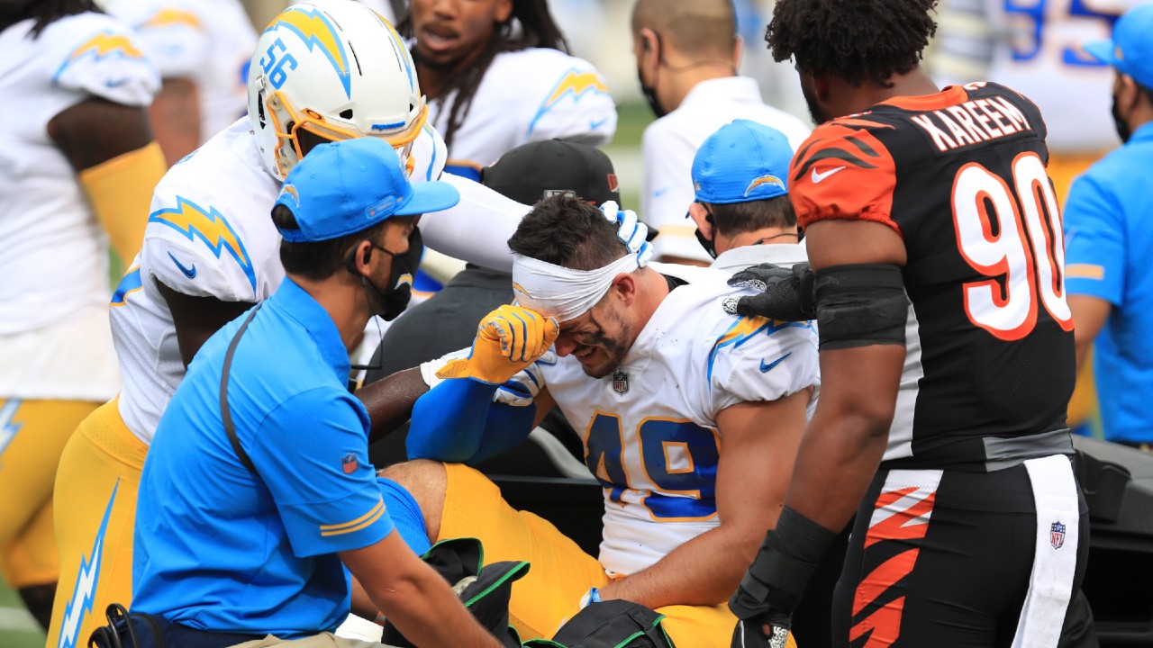 Los Angeles Chargers linebacker Drue Tranquill (49) is comforted by Kenneth Murray (56) and Cincinnati Bengals' Khalid Kareem (90) after being injured during the first half of an NFL football game, Sunday, Sept. 13, 2020, in Cincinnati. (Aaron Doster/AP)