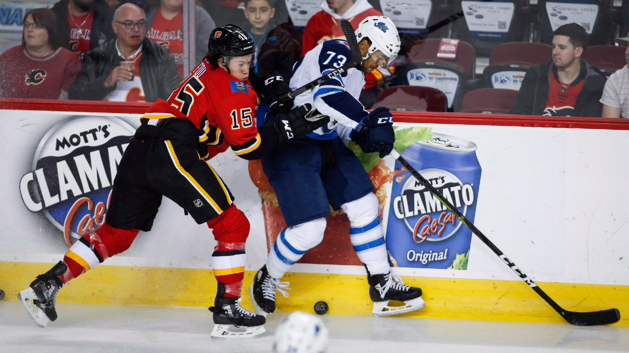 Winnipeg Jets' C.J. Suess, right, is checked by Calgary Flames' Spencer Foo during preseason NHL hockey action in Calgary, Monday, Sept. 24, 2018.(Jeff McIntosh/CP)