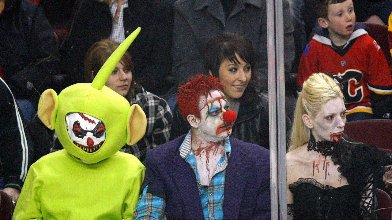 Hockey fans watch the game wearing Halloween costumes as the St. Louis Blues play the Calgary Flames in NHL hockey action. (Jeff McIntosh/CP)