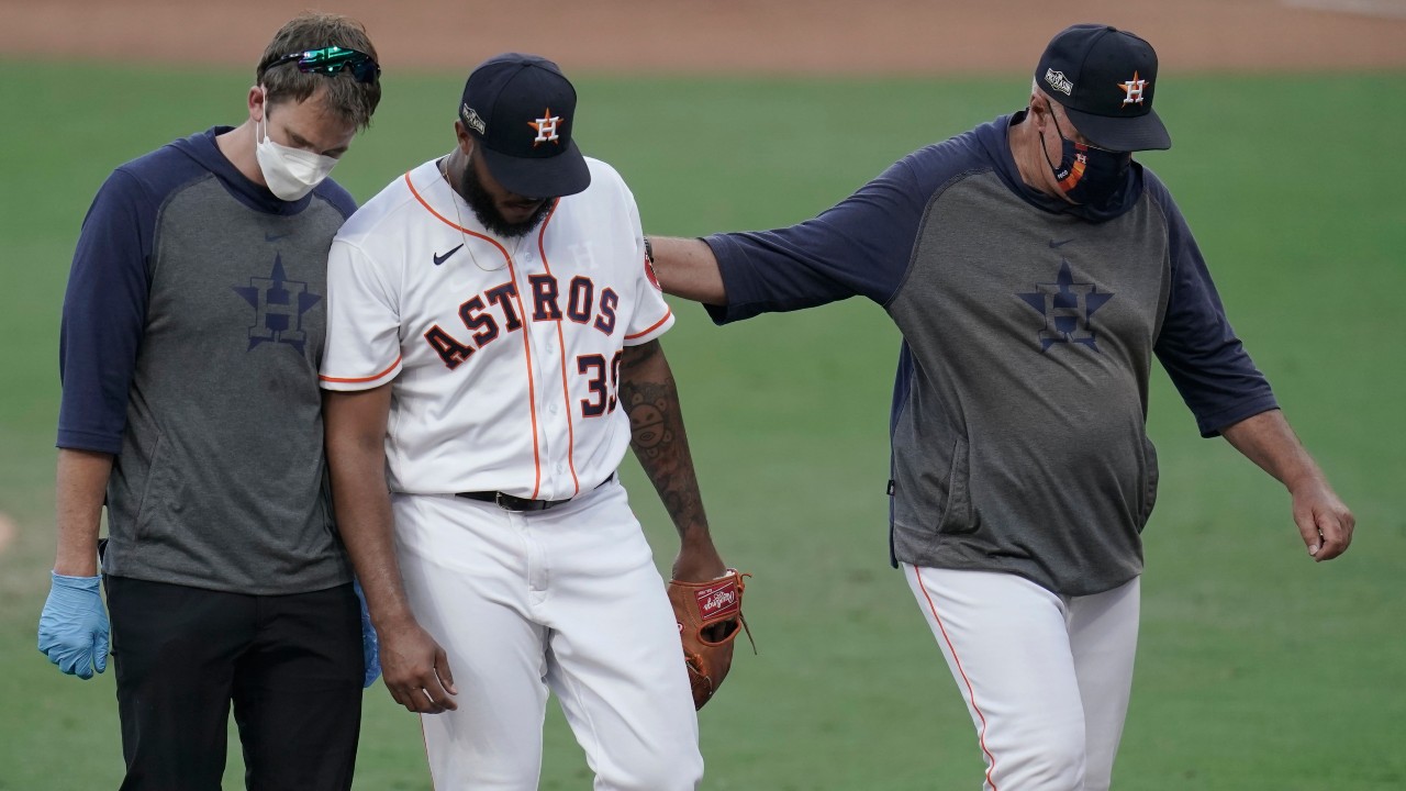 Houston Astros pitcher Josh James is helped off the field during the eighth inning in Game 5 of a baseball American League Championship Series against the Tampa Bay Rays. (Gregory Bull/AP)