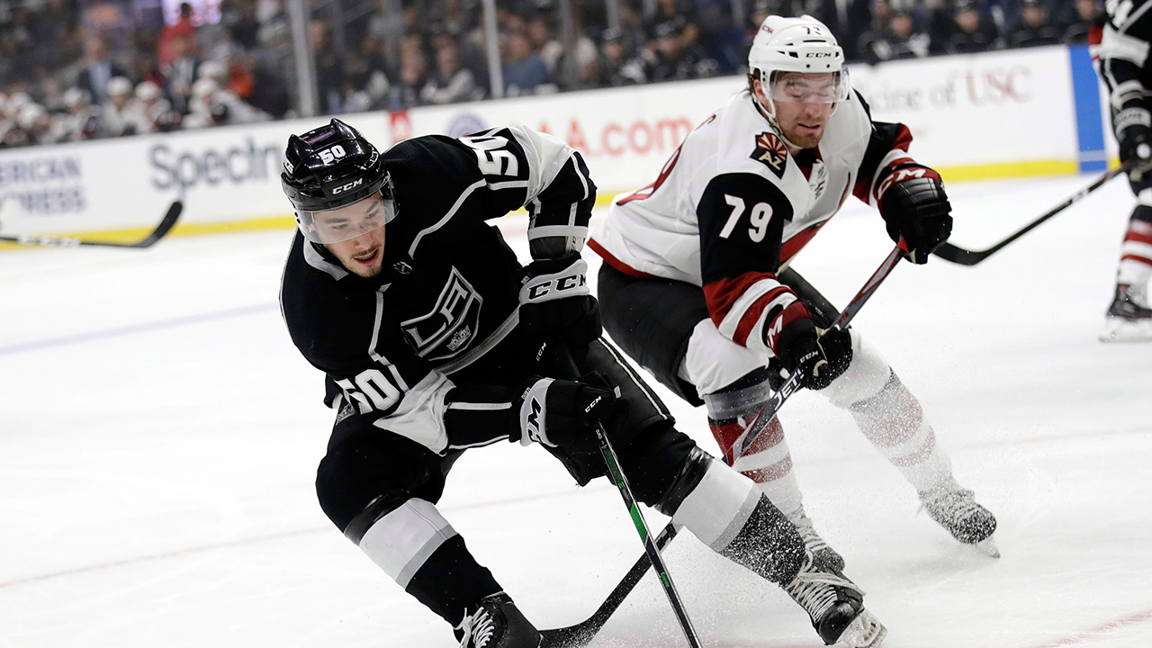 Los Angeles Kings' Sean Durzi, left, reaches for the puck in front of Arizona Coyotes' Jordan Gross during the first period of a pre-season game on Tuesday, Sept. 17, 2019, in Los Angeles. (Marcio Jose Sanchez/AP)