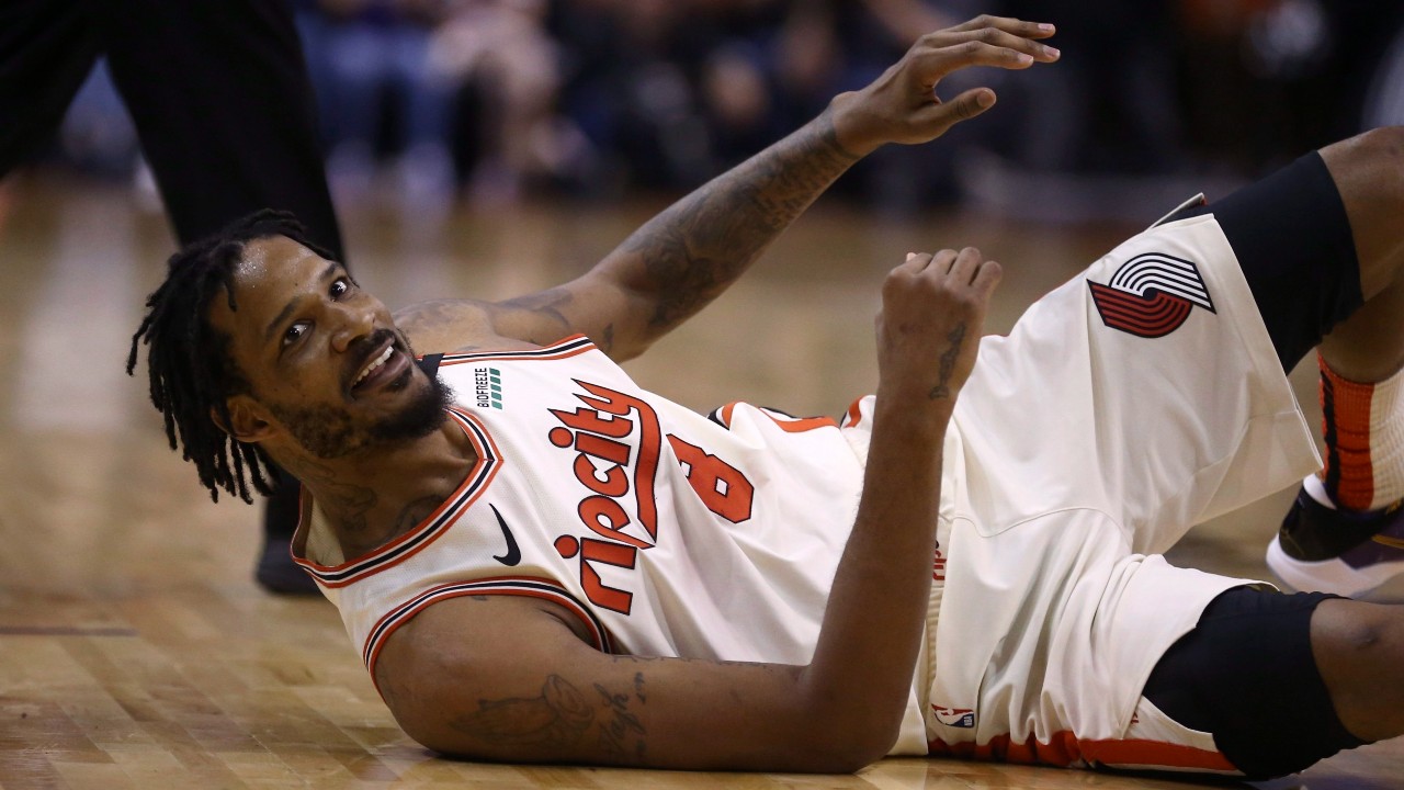 Portland Trail Blazers forward Trevor Ariza smiles at Phoenix Suns' Devin Booker after getting fouled during the first half of an NBA basketball game. (Ross D. Franklin/AP)
