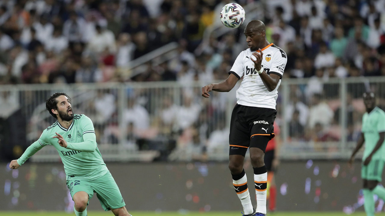 Valencia's Geoffrey Kondogbia heads the ball in front of Real Madrid's Isco, left, during the Spanish Super Cup semifinal soccer match between Real Madrid and Valencia. (Hassan Ammar/AP)