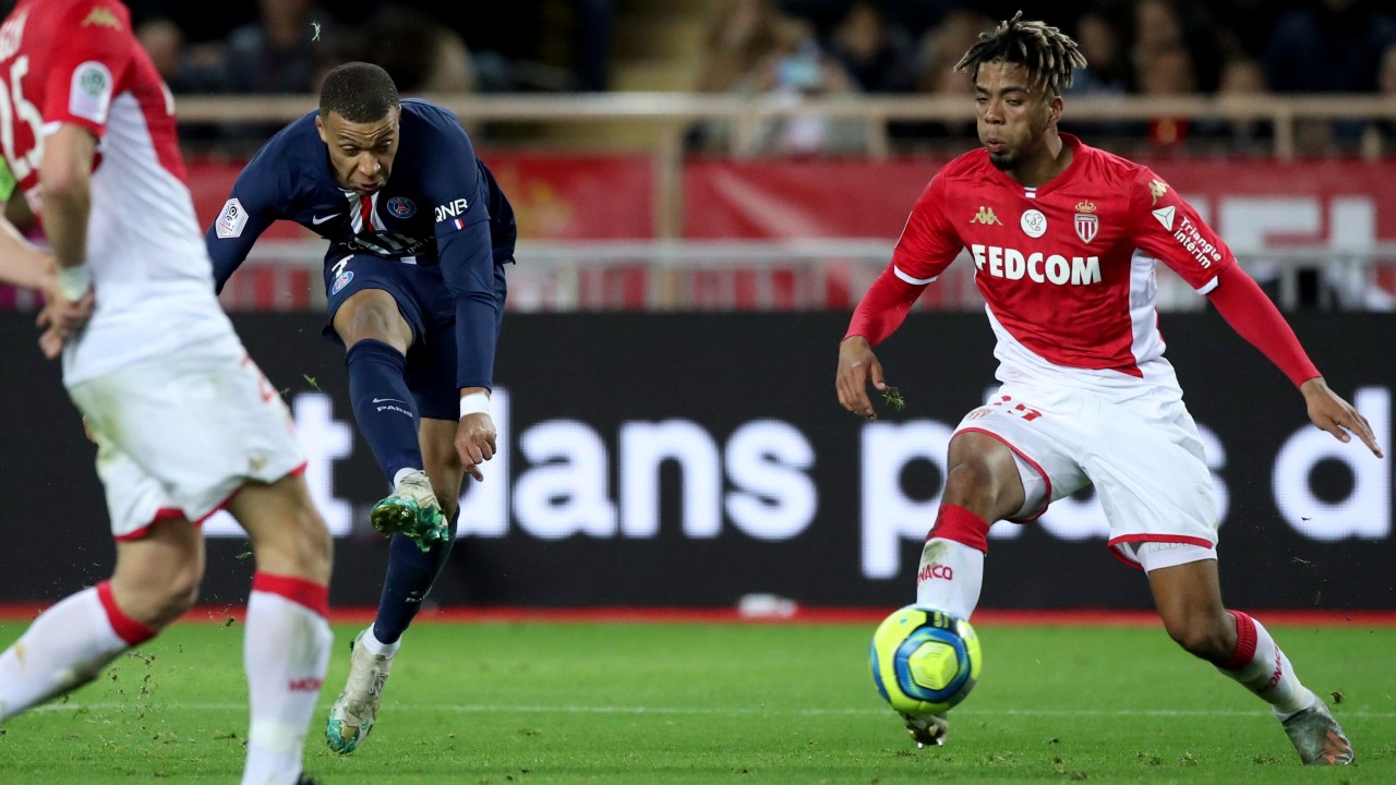 PSG's Kylian Mbappe, left, shoots during the French League One soccer match between Monaco and Paris Saint-Germain. (Daniel Cole/AP)