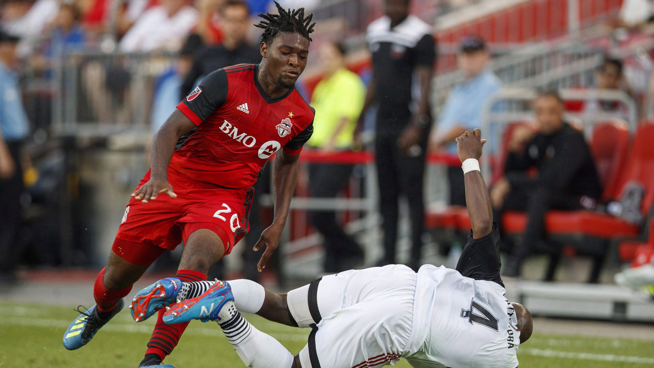 Toronto FC's Ayo Akinola battles for the ball with Ottawa Fury FC's Nana Attakora, right, during the first half of Canadian Championship soccer action. (Mark Blinch/CP)