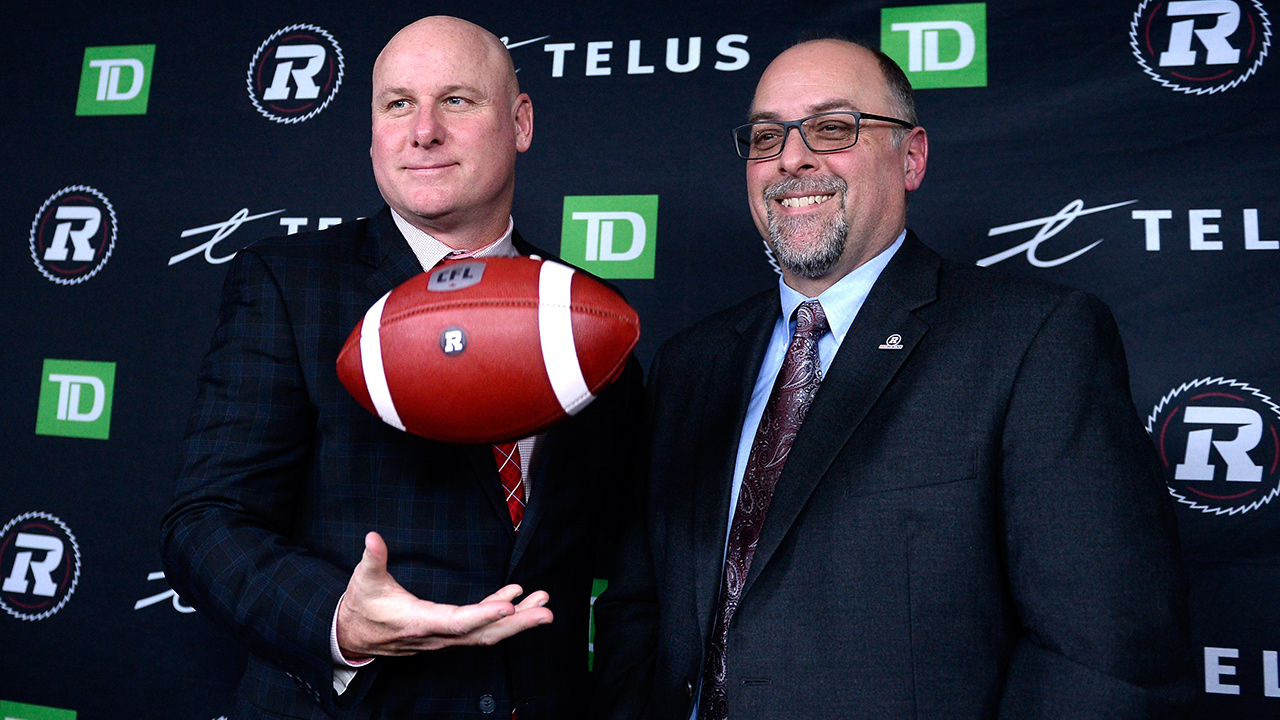 New Ottawa Redblacks head coach Paul LaPolice tosses a ball as he stands with general manager Marcel Desjardins for photos after a press conference in Ottawa, on Monday, Dec. 9, 2019. (Justin Tang/CP)