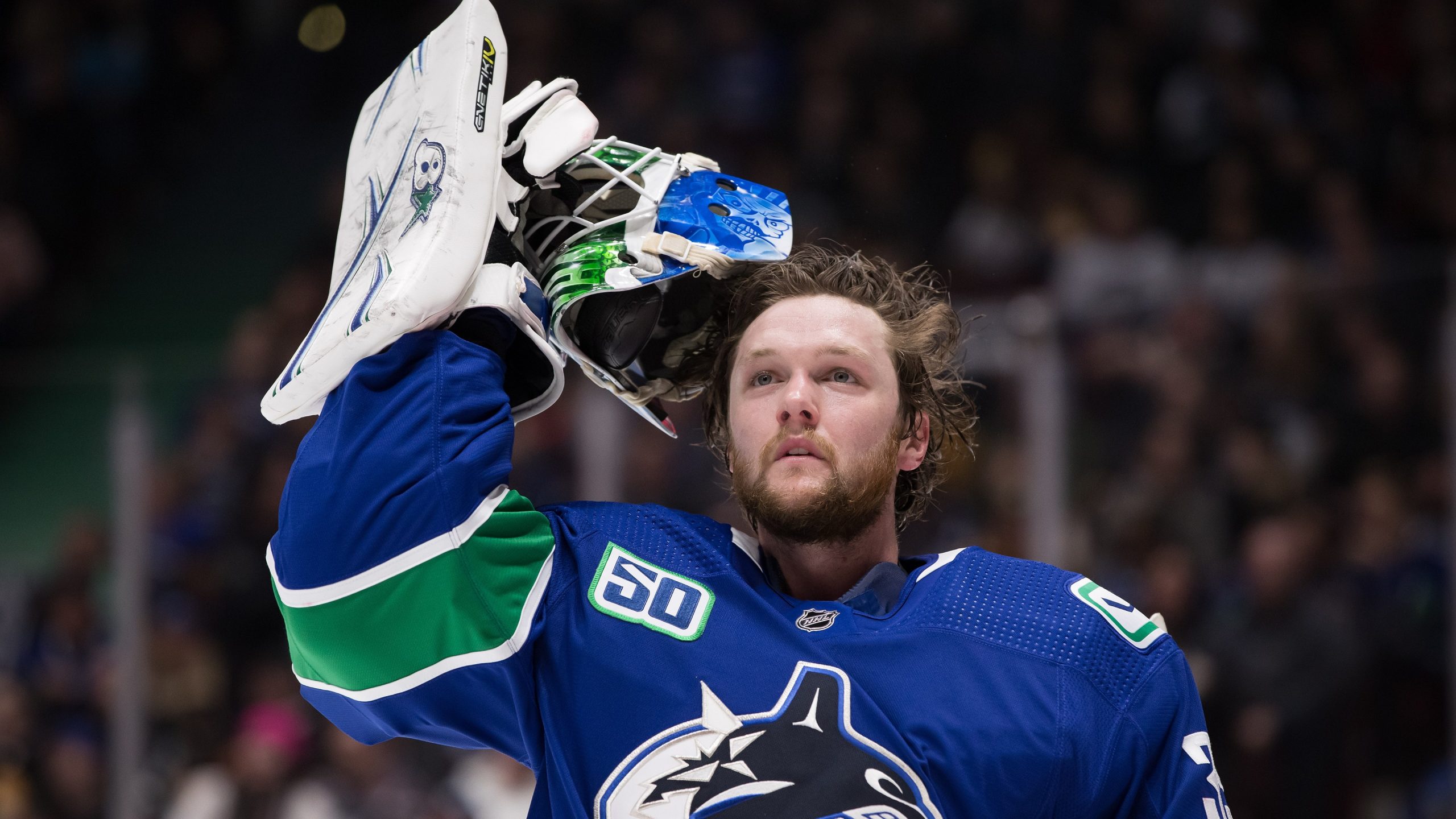 Vancouver Canucks goalie Thatcher Demko takes off his mask during a stoppage in play against the St. Louis Blues during the first period of an NHL hockey game. (Darryl Dyck/CP)