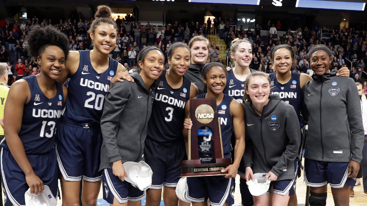 Connecticut players pose for photos with the trophy after defeating Louisville in a regional championship final in the 2019 NCAA women's college basketball tournament. (Kathy Willens/AP)
