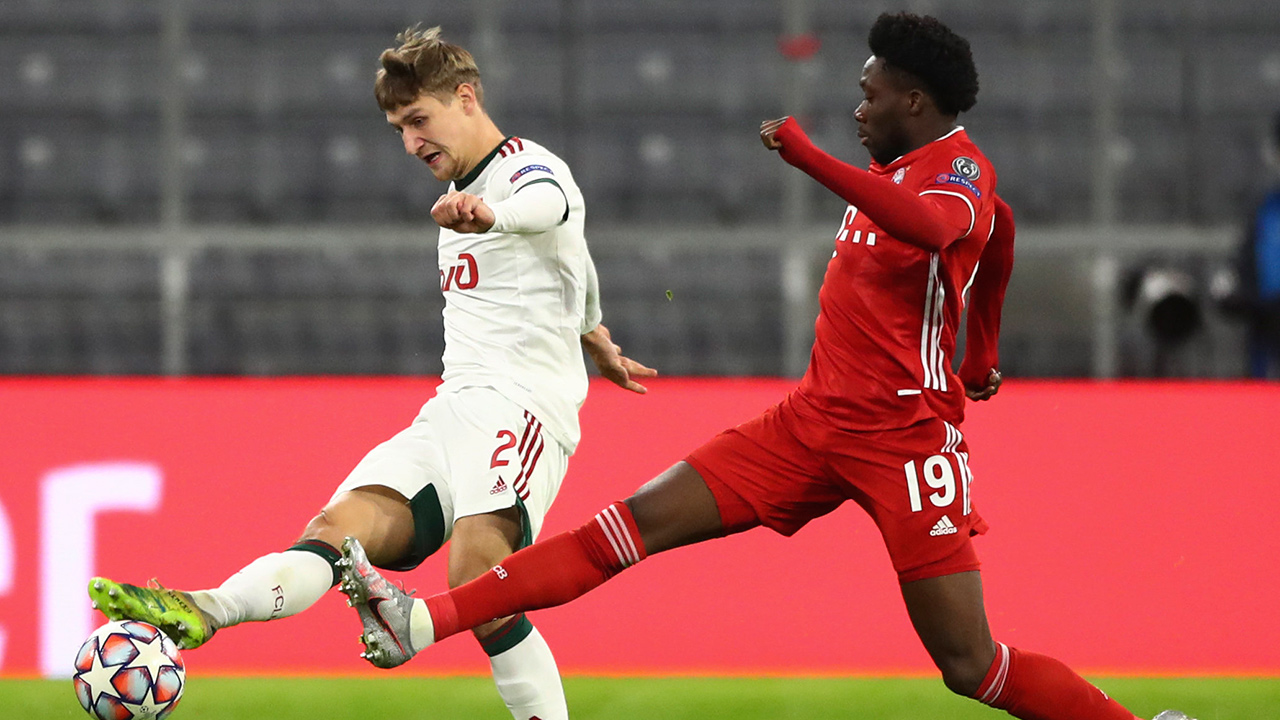Lokomotiv's Dmitri Zhivoglyadov, left, shoots the ball as Bayern's Alphonso Davies, right, tries to stop him during the Champions League Group A match at the Allianz Arena in Munich, Germany, Wednesday, Dec. 9, 2020. (Matthias Schrader/AP)