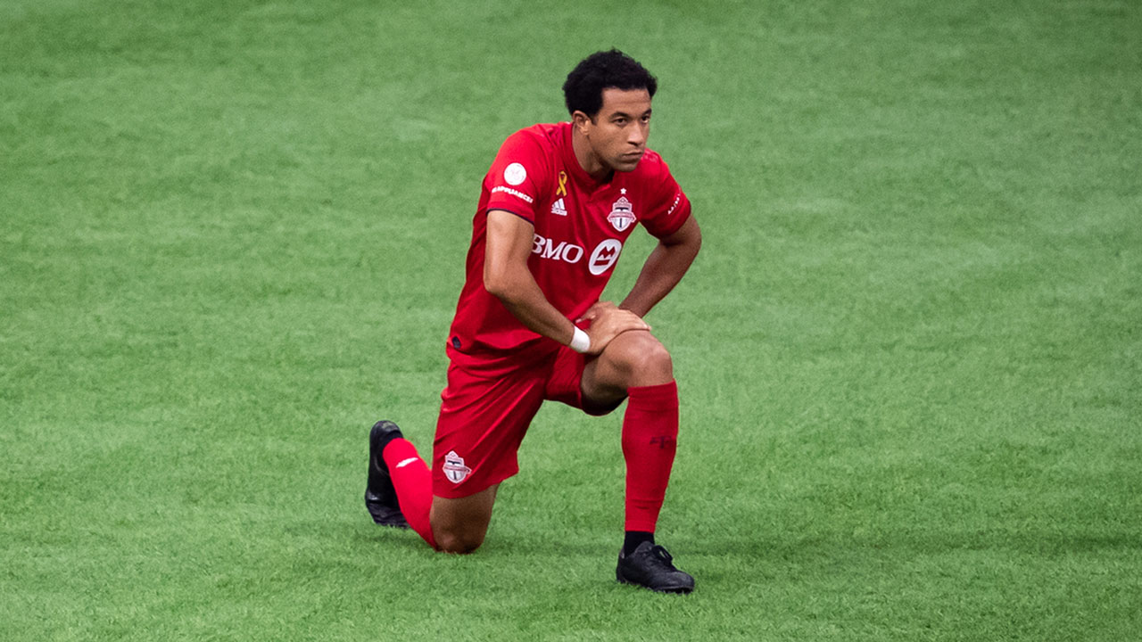 Toronto FC's Justin Morrow takes a knee before an MLS soccer game against the Vancouver Whitecaps in Vancouver. (Darryl Dyck/CP)