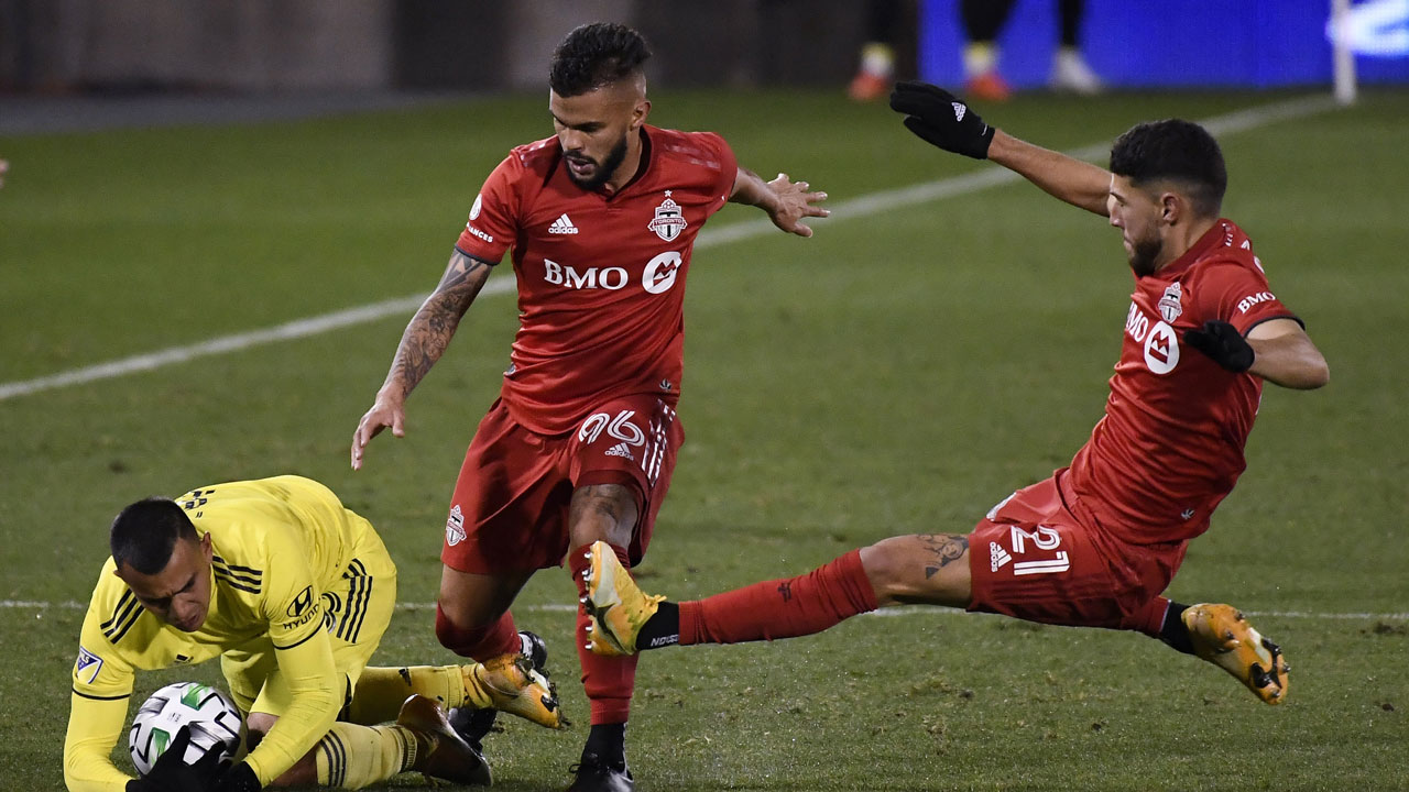 Nashville SC's Randall Leal, left, falls next to Toronto FC's Auro Jr., center, and Jonathan Osorio during the second half of an MLS soccer playoff match. (Jessica Hill/AP)