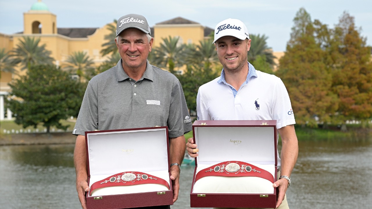 Justin Thomas, right, and his father Mike Thomas pose with the championship trophies after winning the PNC Championship golf tournament, Sunday, Dec. 20, 2020, in Orlando, Fla. (Phelan M. Ebenhack/AP)