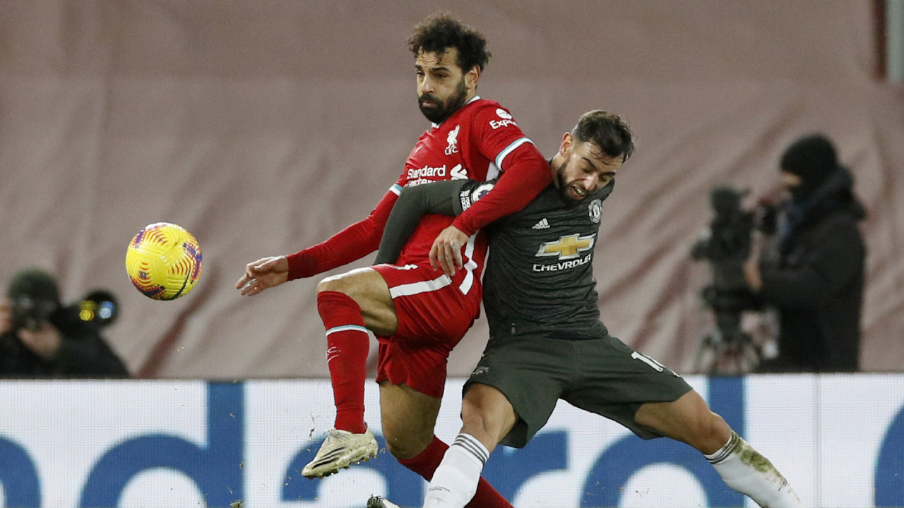 Manchester United's Bruno Fernandes fights for the ball with Liverpool's Mohamed Salah, left, during the English Premier League soccer match between Liverpool and Manchester United at Anfield Stadium, Liverpool, England, Sunday, Jan. 17, 2021. (Phil Noble/Pool via AP)