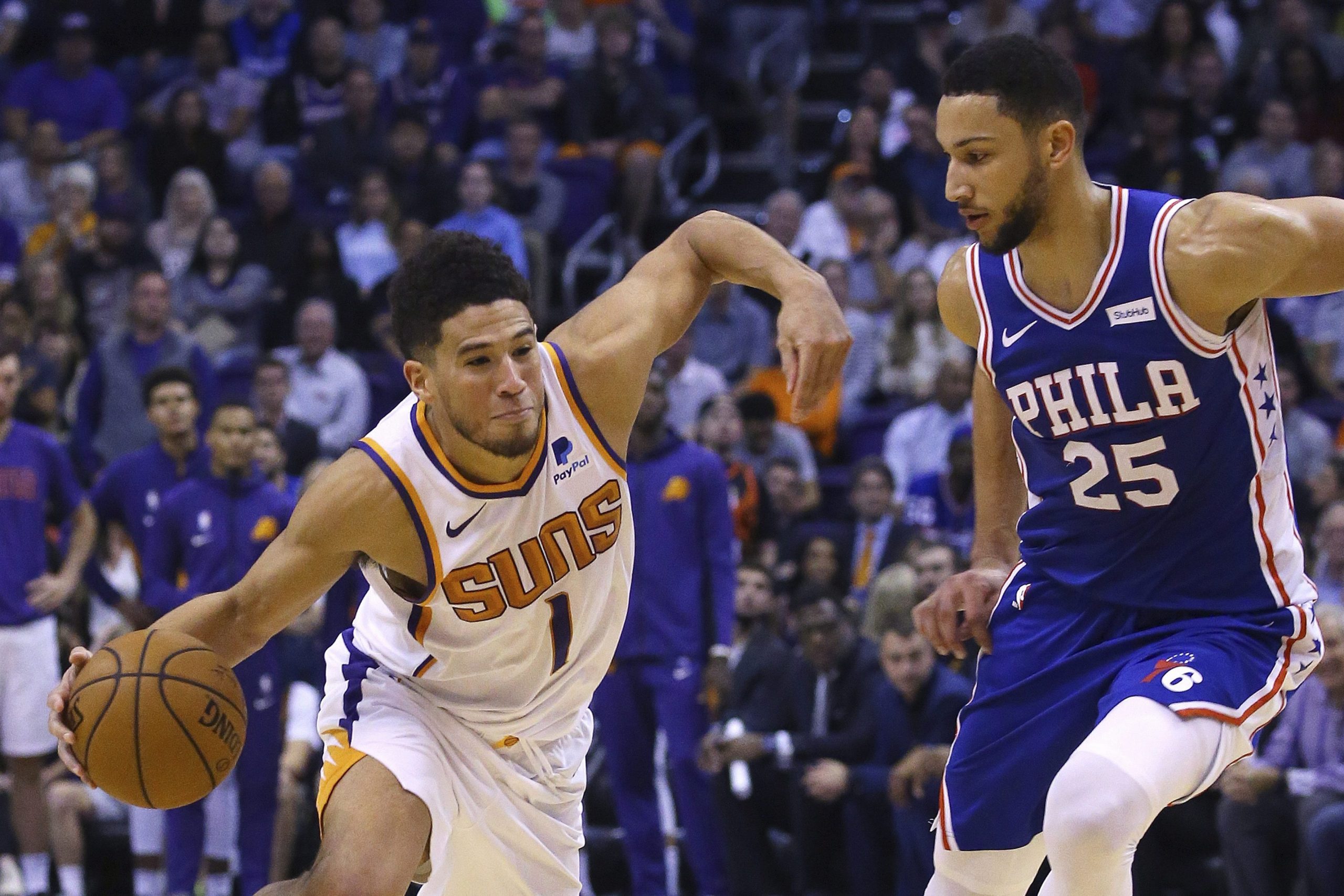 Phoenix Suns guard Devin Booker (1) drives past Philadelphia 76ers guard Ben Simmons (25) during the second half of an NBA basketball game. (Ross D. Franklin/AP) 