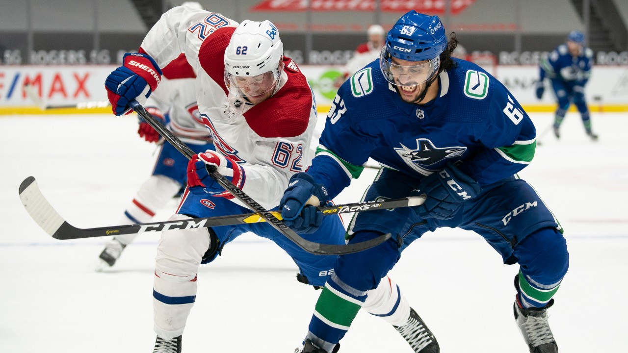 Vancouver Canucks defenceman Jalen Chatfield (63) fights for control of the puck with Montreal Canadiens left wing Artturi Lehkonen (62) during third period NHL action. (Jonathan Hayward/CP)