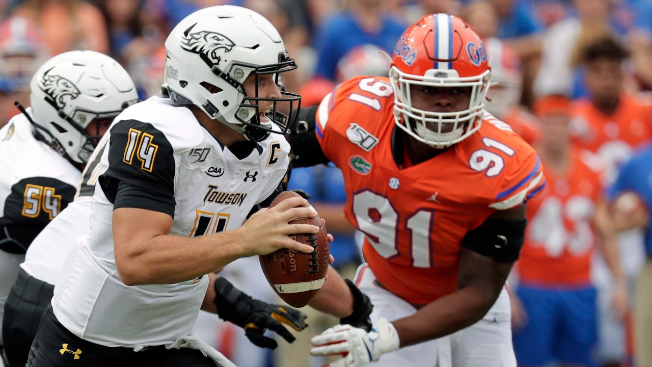 Towson quarterback Tom Flacco (14) scrambles from the pocket as he is pressured by Florida defensive lineman Marlon Dunlap Jr. (91) during the first half of an NCAA college football game. (John Raoux/AP)